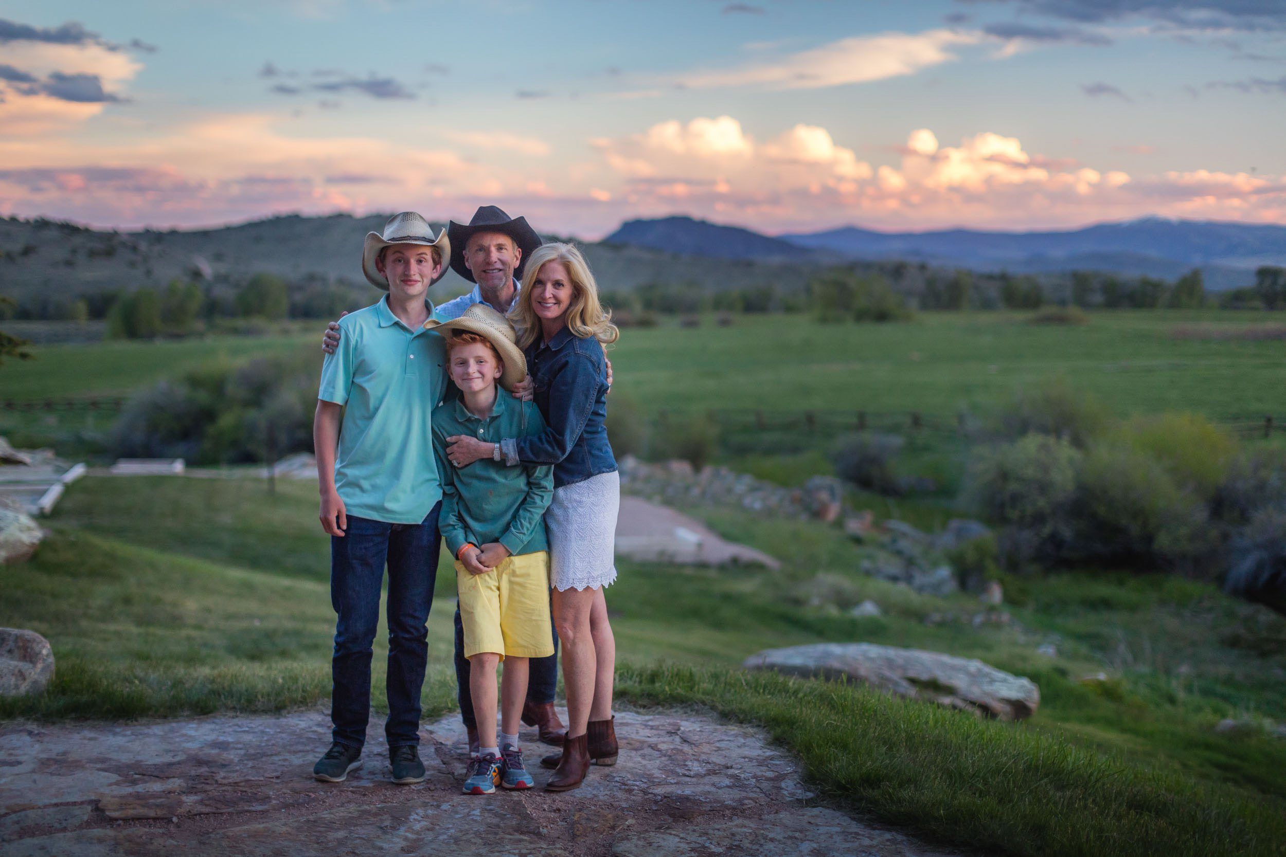 family of four posing with a view of the landscape